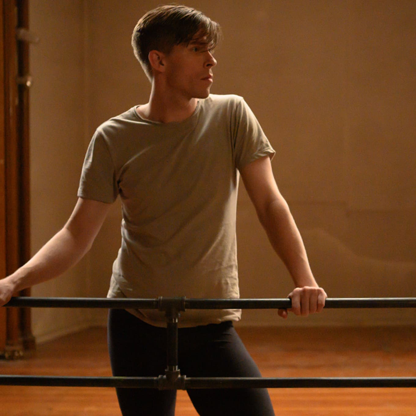 Chad holding onto a bar and standing.