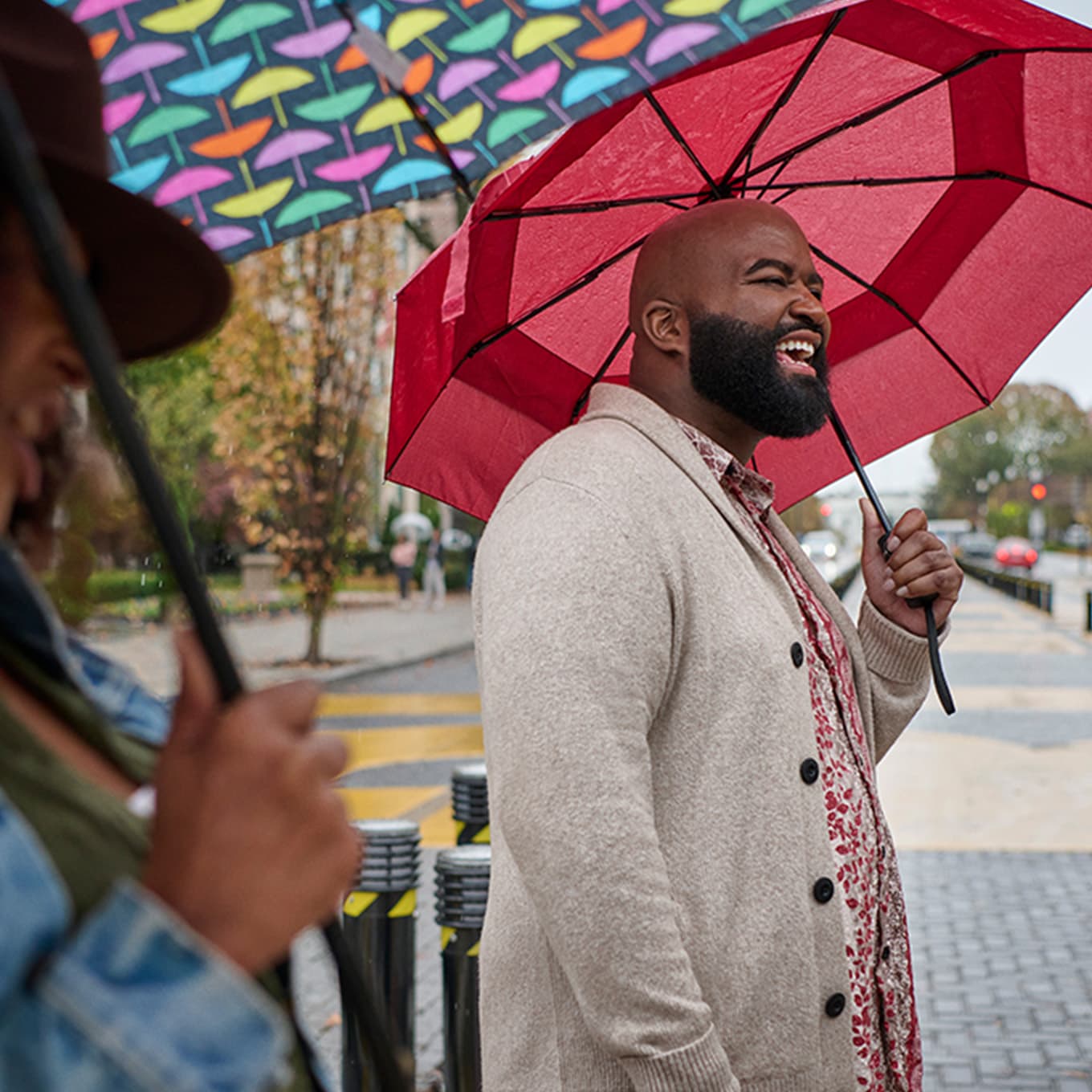 Phil holding an umbrella outside and smiling.