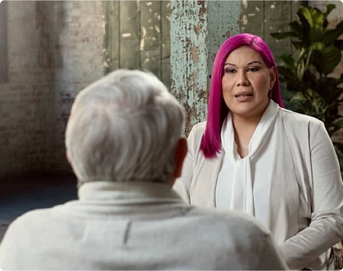 D’Eva with pink hair is speaking to Hugo.