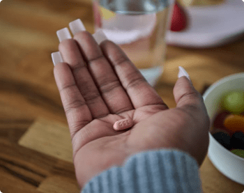 Nikki is holding a pill.