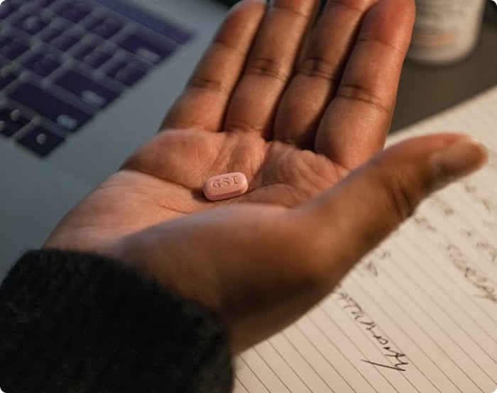 Phil holding a pill in his hand.