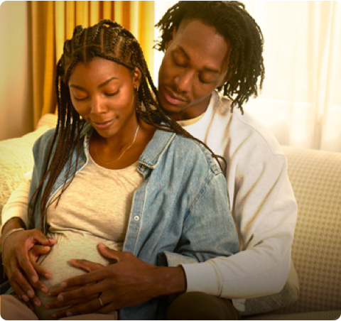 A pregnant woman with a man behind her.