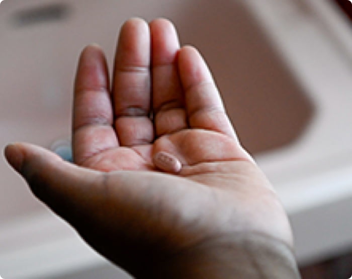 Tamera holding a Biktarvy pill.