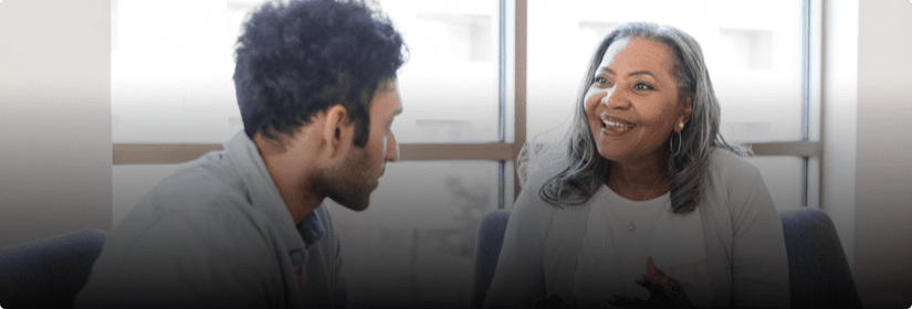 A woman talking to a man while he listens to her.