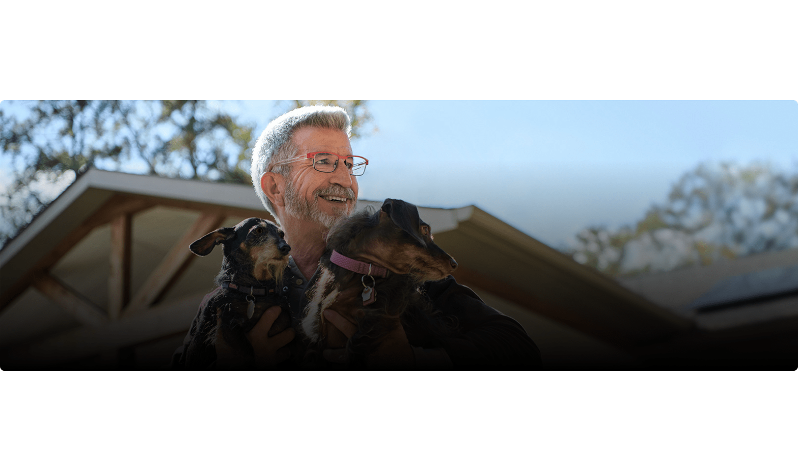 Theron is smiling and holding dogs.