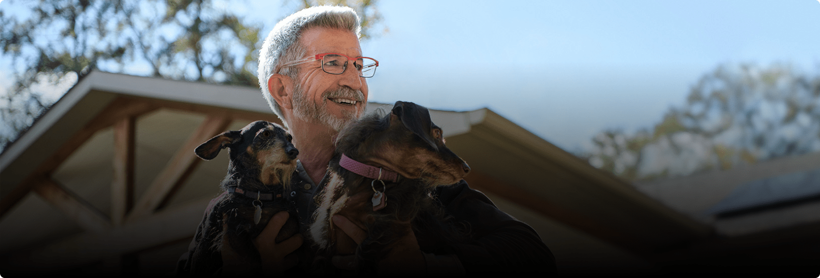 Theron is smiling and holding dogs.