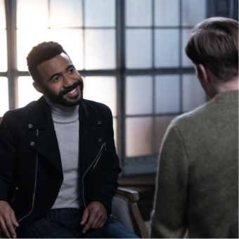 Dimitri is smiling in conversation with someone.