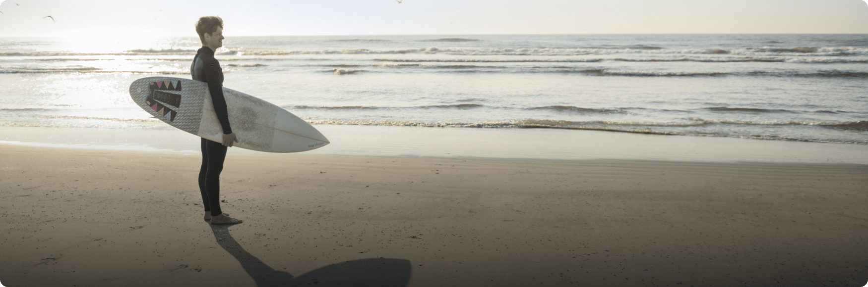 hombre activo con tabla de surf en la playa