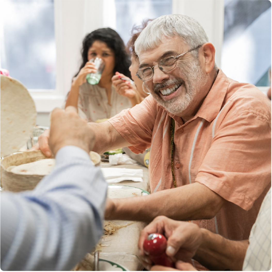 Hugo sonríe sentado a la mesa comedor.