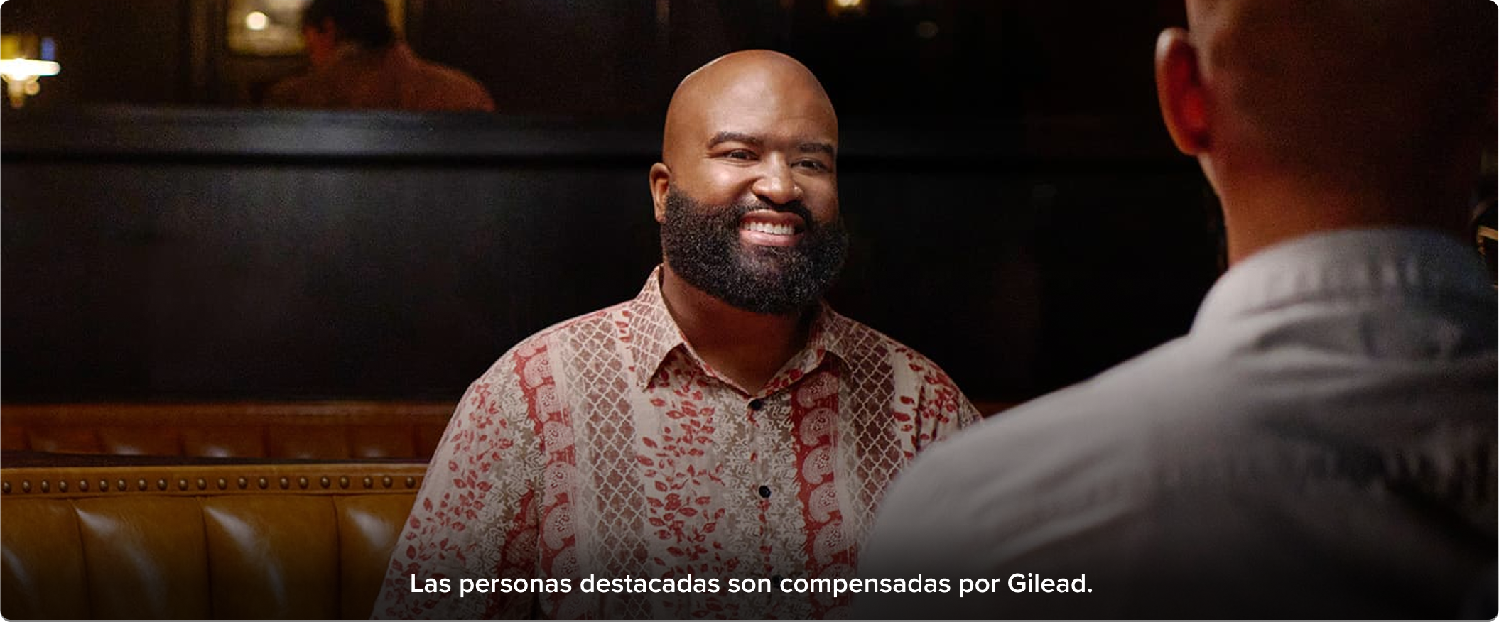 hombre sonríe mientras mantiene una conversación